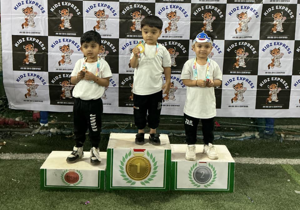 Confident young children standing on a winners' podium